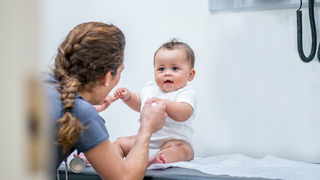 Pediatric nurse playing with baby
