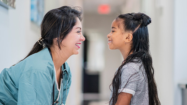 Young girl smiling with nurse in pediatric psychiatry clinic