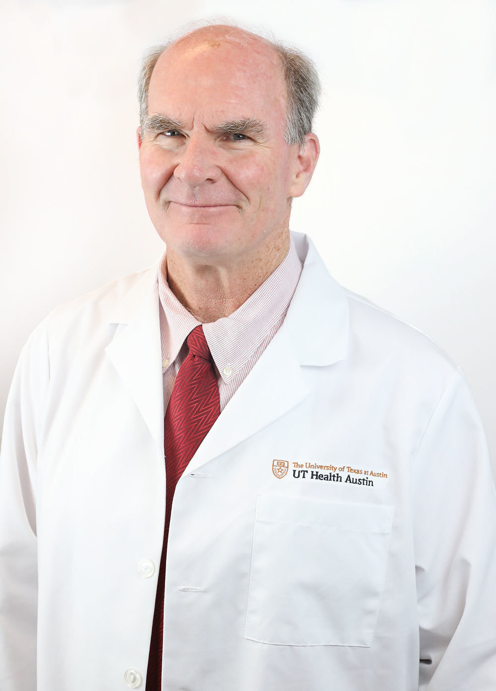 Dr. Michael Breen wearing a white coat and smiling in front of a white backdrop.