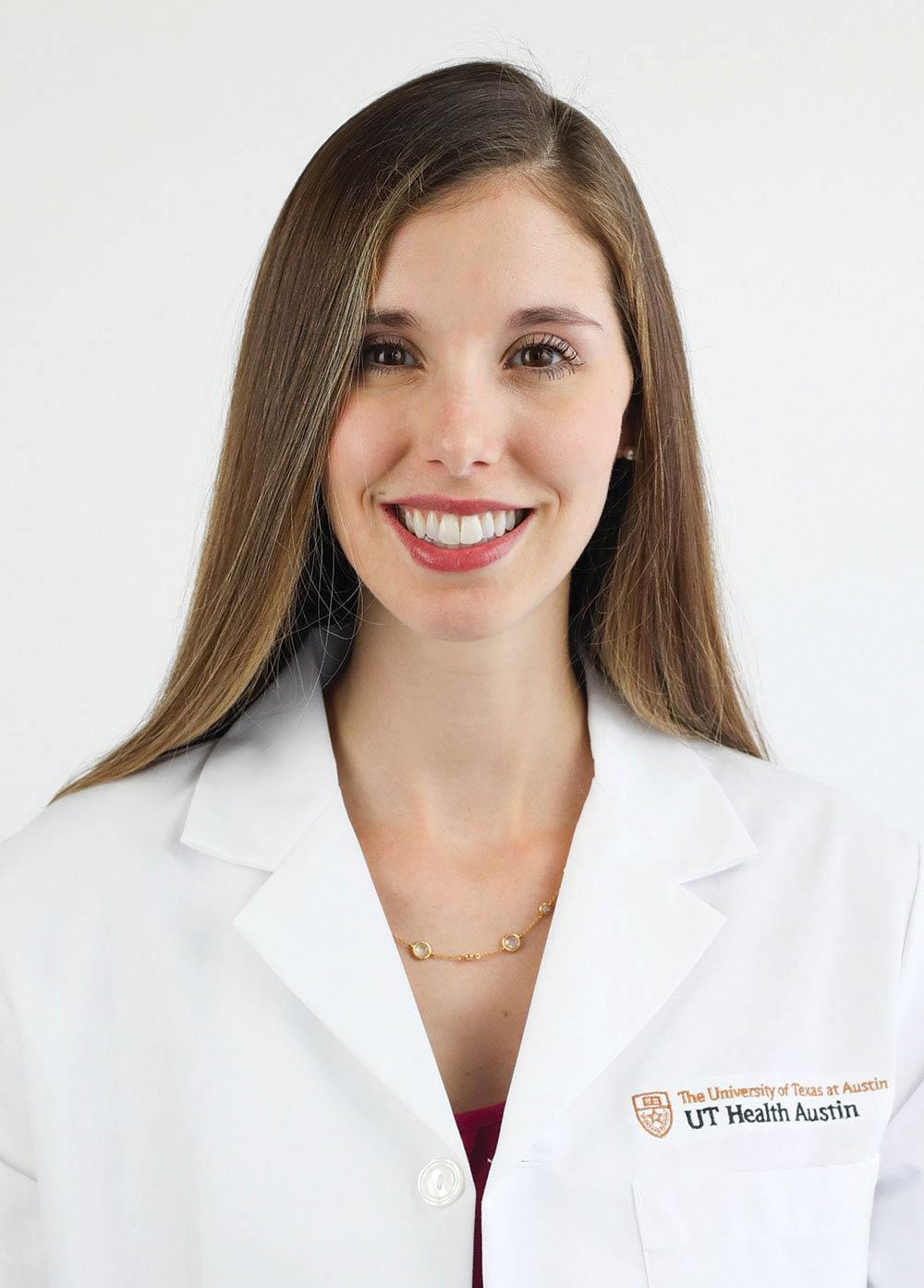 Dr. Amy Papermaster wearing a white coat and smiling in front of a white background.