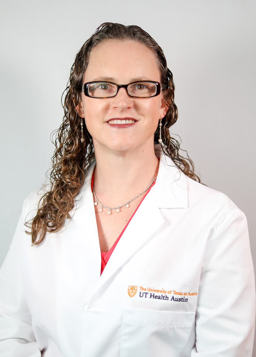 Dr. Linda Feagins wearing a white coat and smiling in front of a white backdrop.