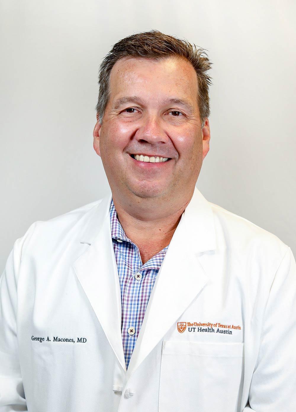 Dr. George A. Macones wearing a white coat and smiling in front of a white background.