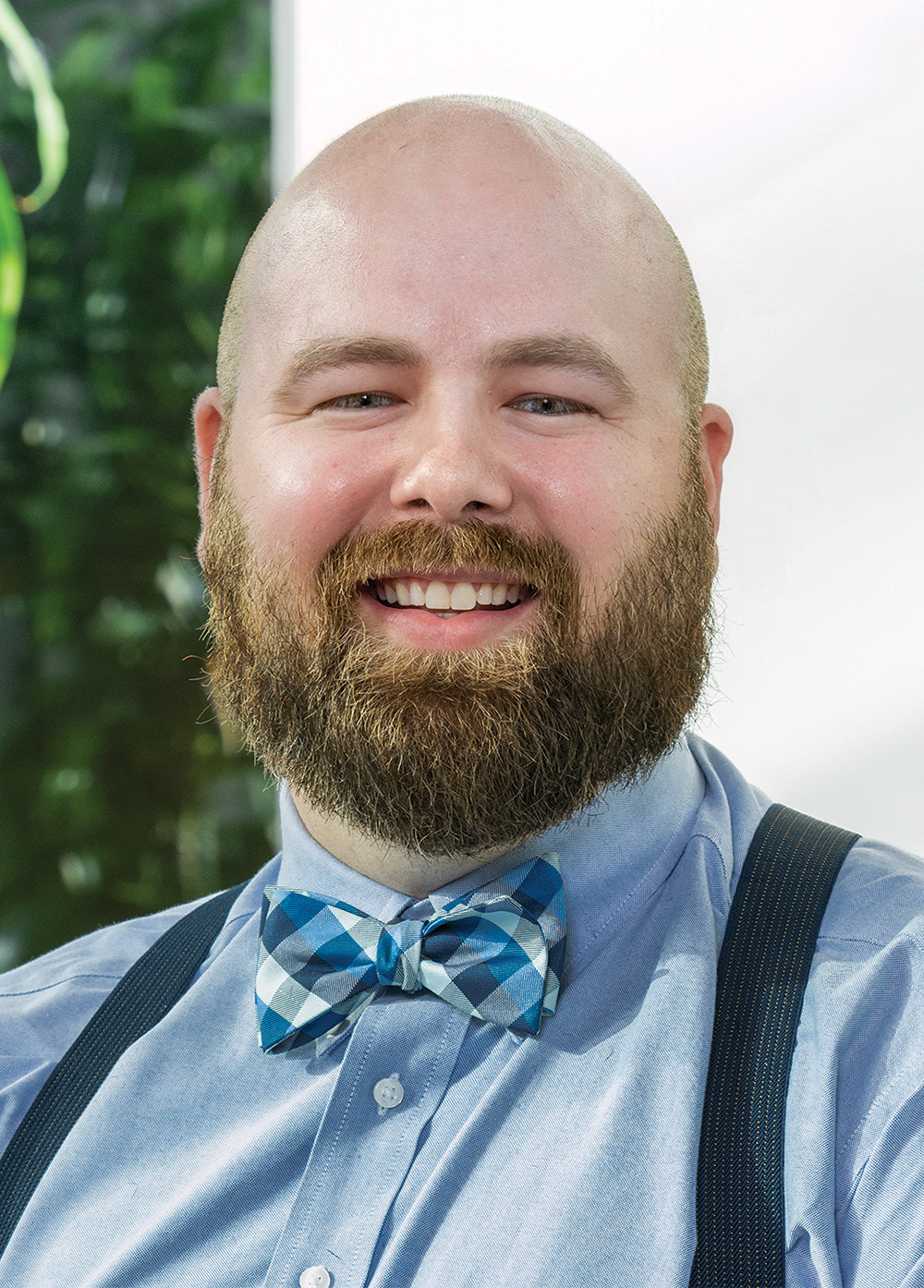 Neuromuscular Program Coordinator James Johnson, BSN, RN, CPN, smiling in a blue shirt, suspenders, and bow tie.