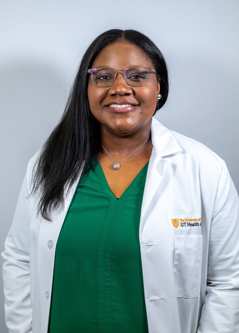 Dr. Mariel Cannady wearing a white coat and smiling in front of a white backdrop.