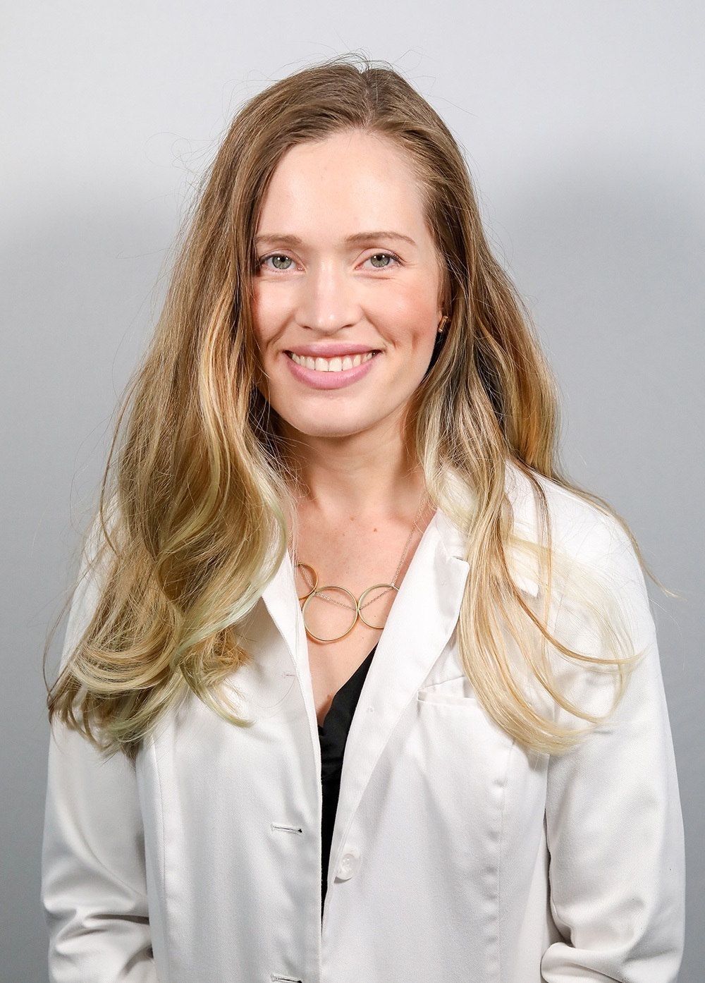 Dr. Michele Lagrone wearing a white coat and smiling in front of a white backdrop.
