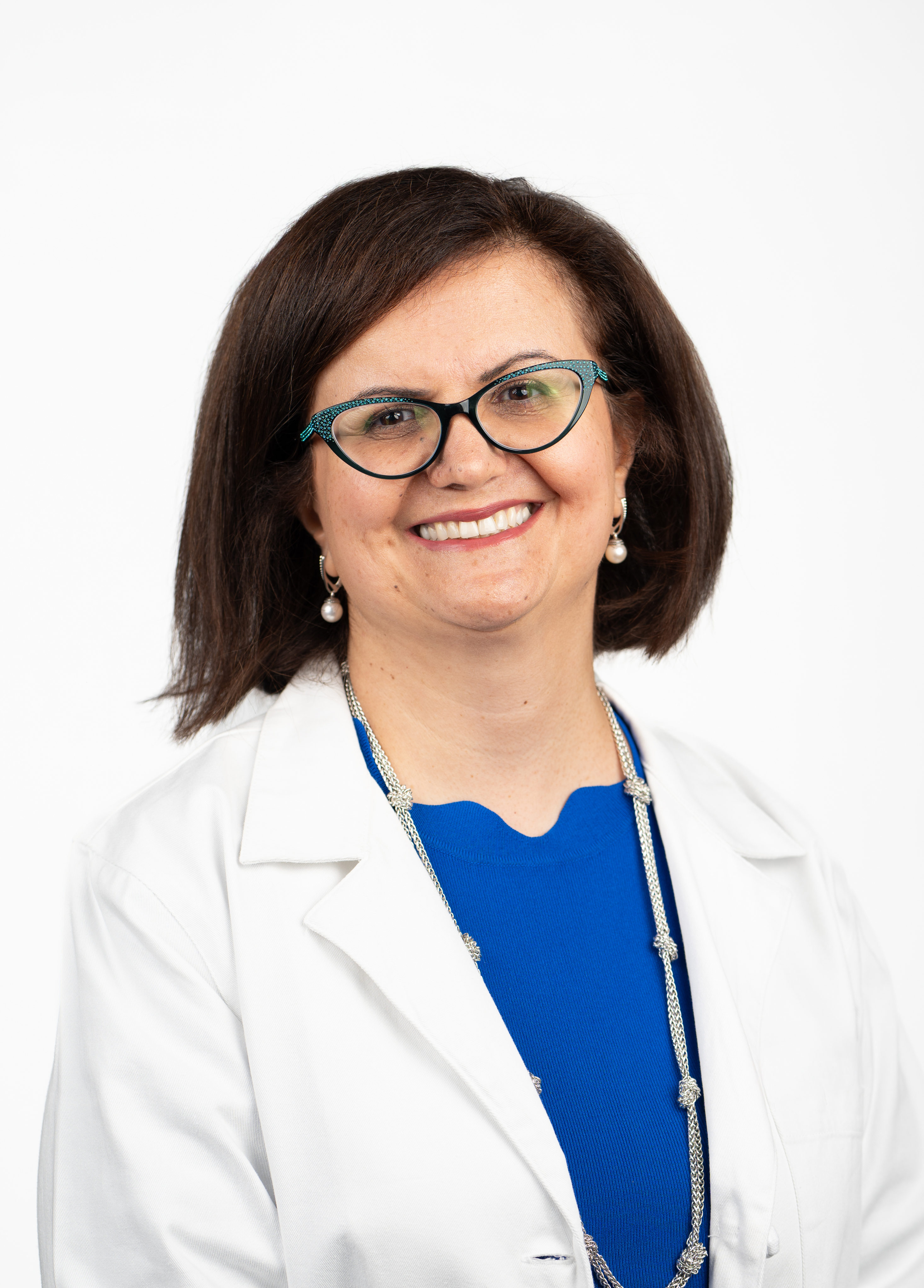 Headshot of Nasim Hedayati. She is wearing a blue blouse and a white coat.