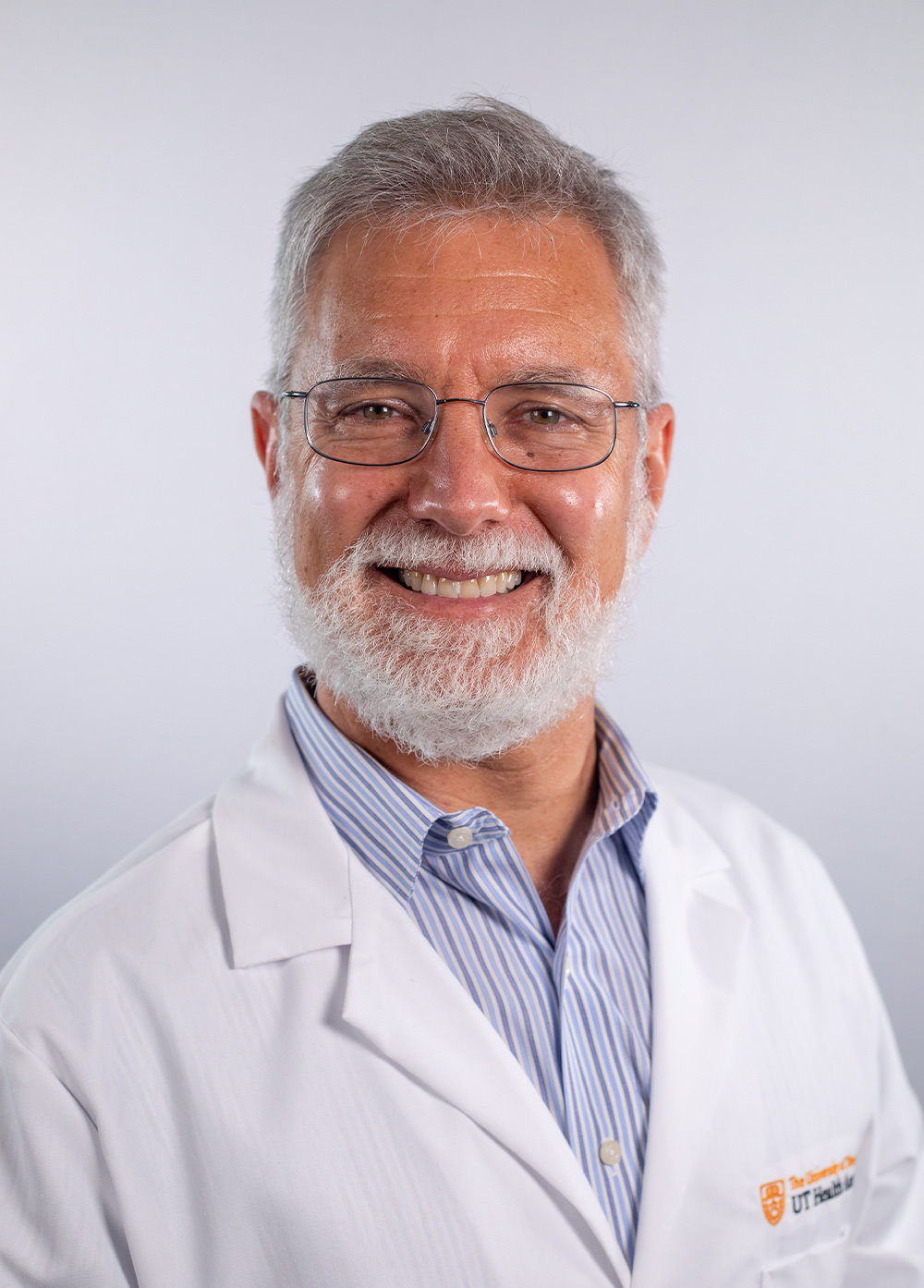 Dr. J. Stuart Wolf, Jr., wearing a white coat and smiling in front of a white backdrop.