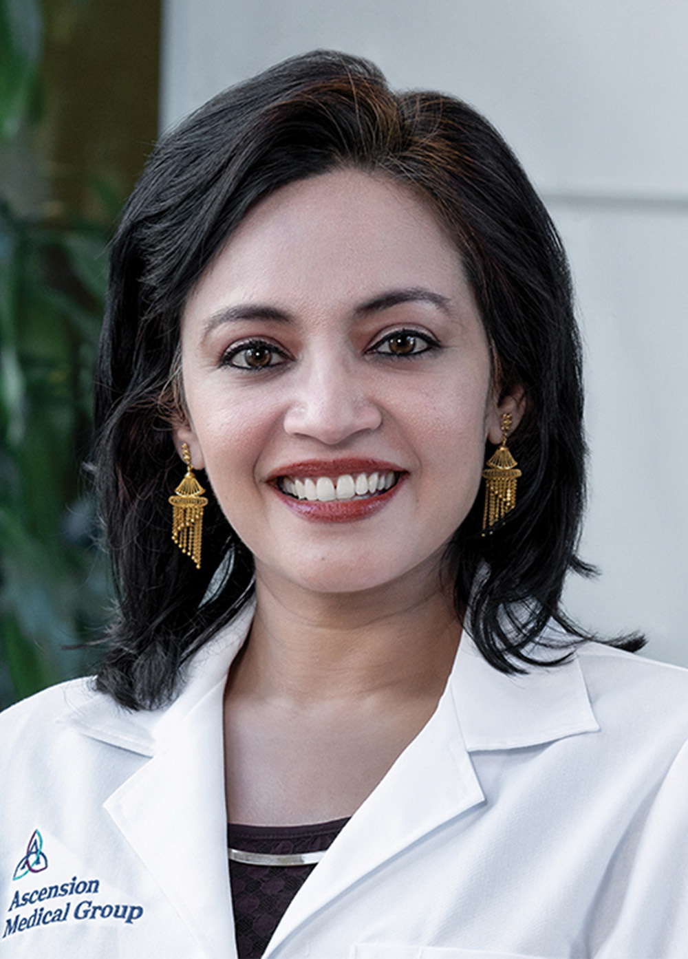 Nurse practitioner Taskina Chowdhury, DNP, APRN, CPNP, smiling and wearing a white coat with an embroidered Dell Children's Medical Center logo.