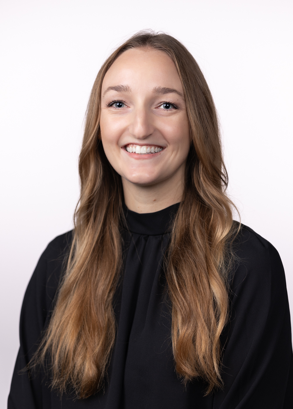 Anastasia Dixon, LMSW, smiling and looking at the camera against a white backdrop. She is wearing a black blouse.