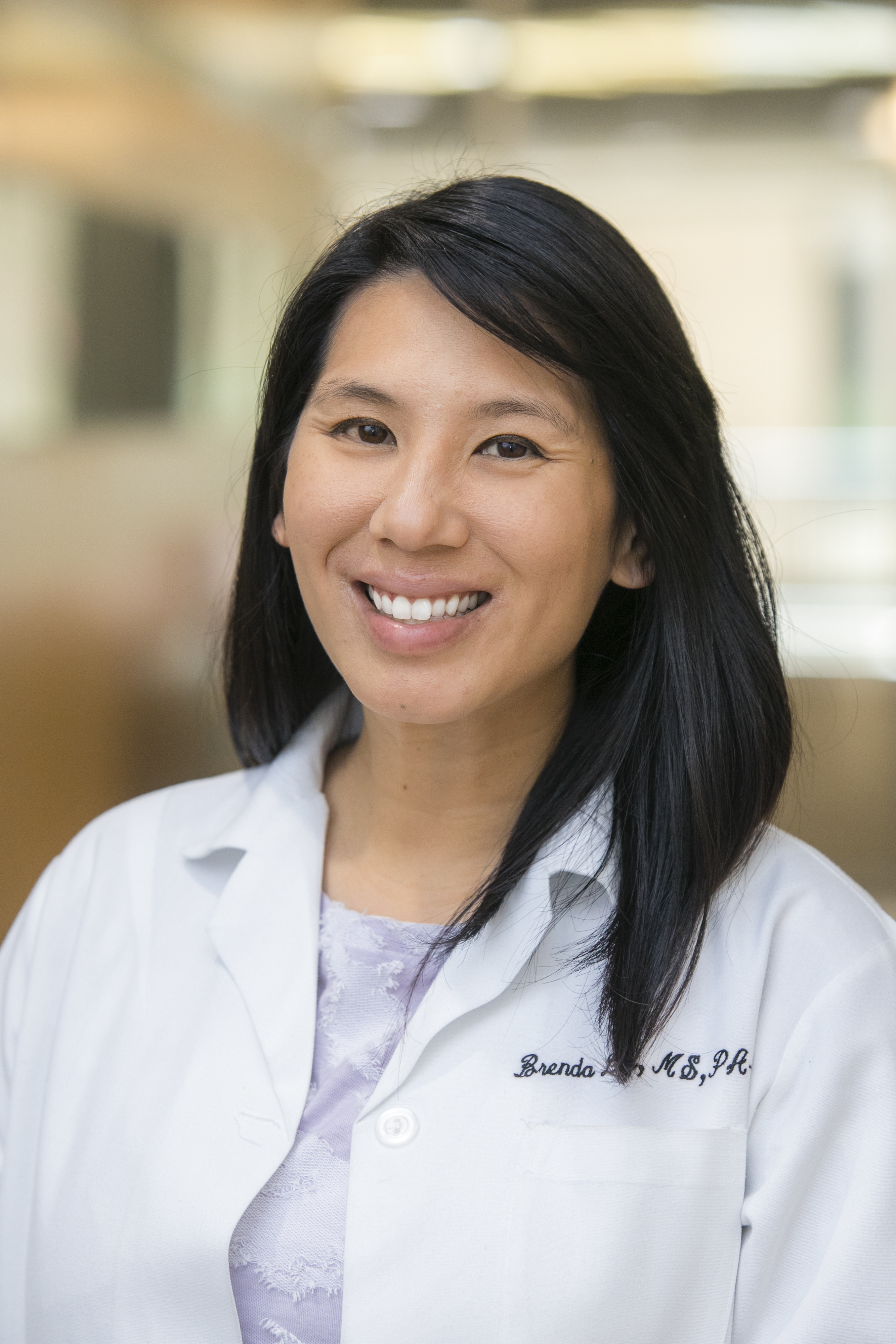 Brenda Chang wearing a white coat and smiling indoors.