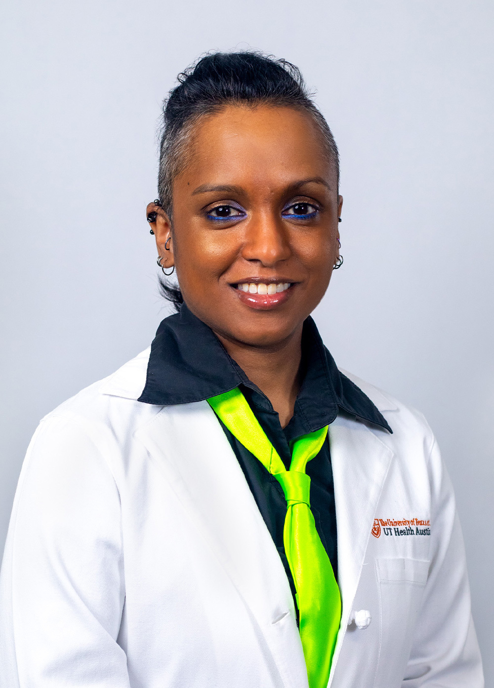 Dr. Camille N. Immanuel wearing a white coat and smiling in front of a white backdrop.