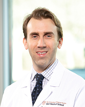 Urologist E. Charles Osterberg, III, MD, FACS, wearing a white coat and smiling in front of a widow.