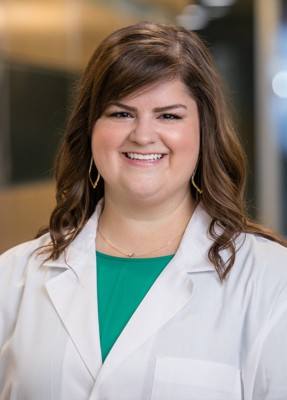 Danielle Doucet wearing a white coat and smiling indoors.