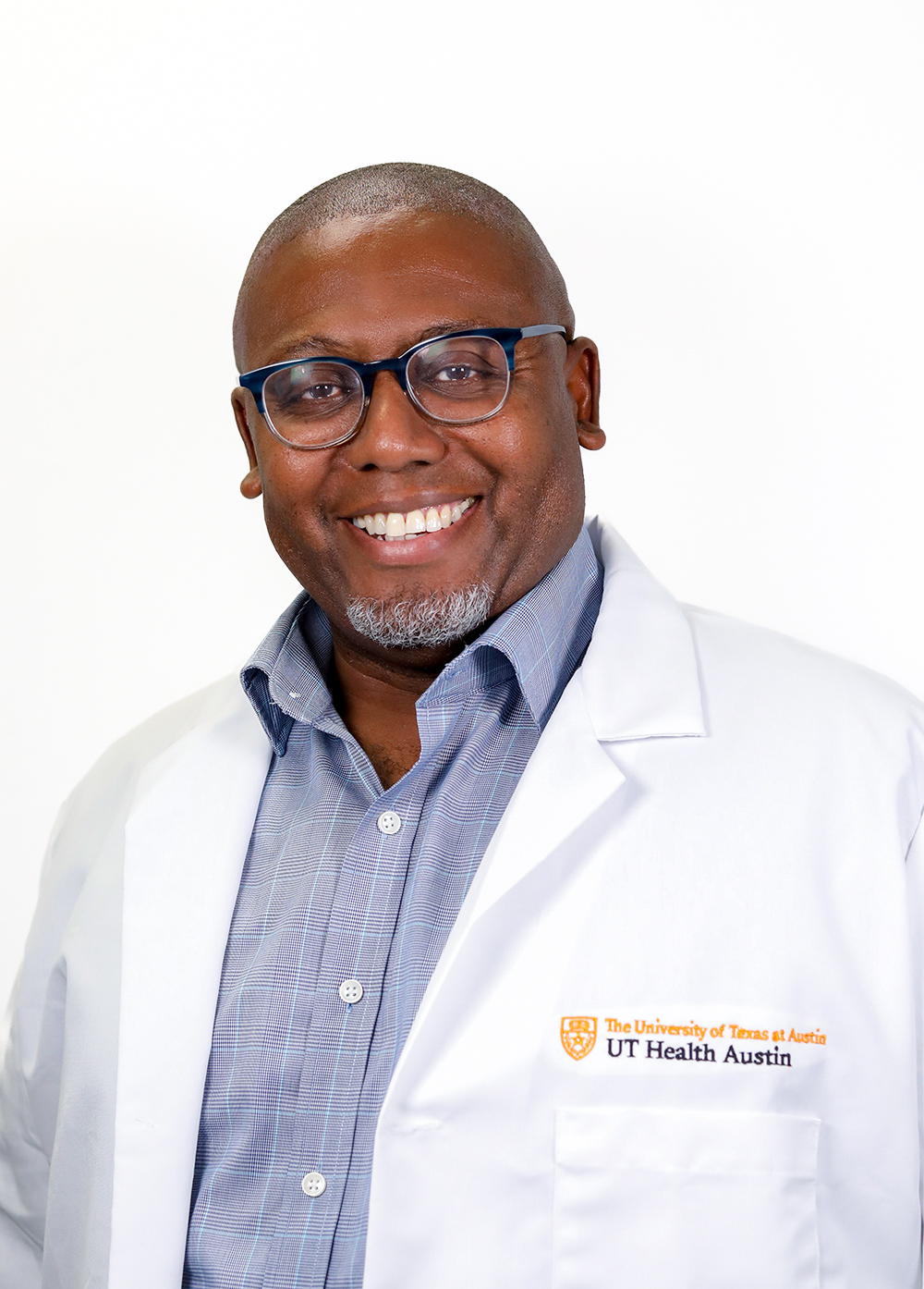 Dr. Dave Clarke is wearing a white coat and smiling in front of a white backdrop.