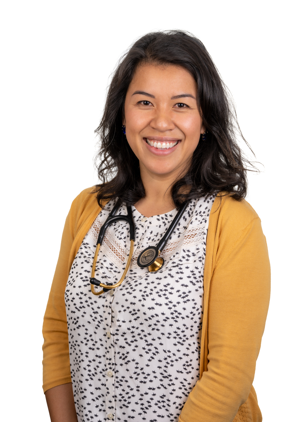 Pediatrician Hanh Keyburn, DO, with a stethescope around her shoulders and smiling in front of a white backdrop.