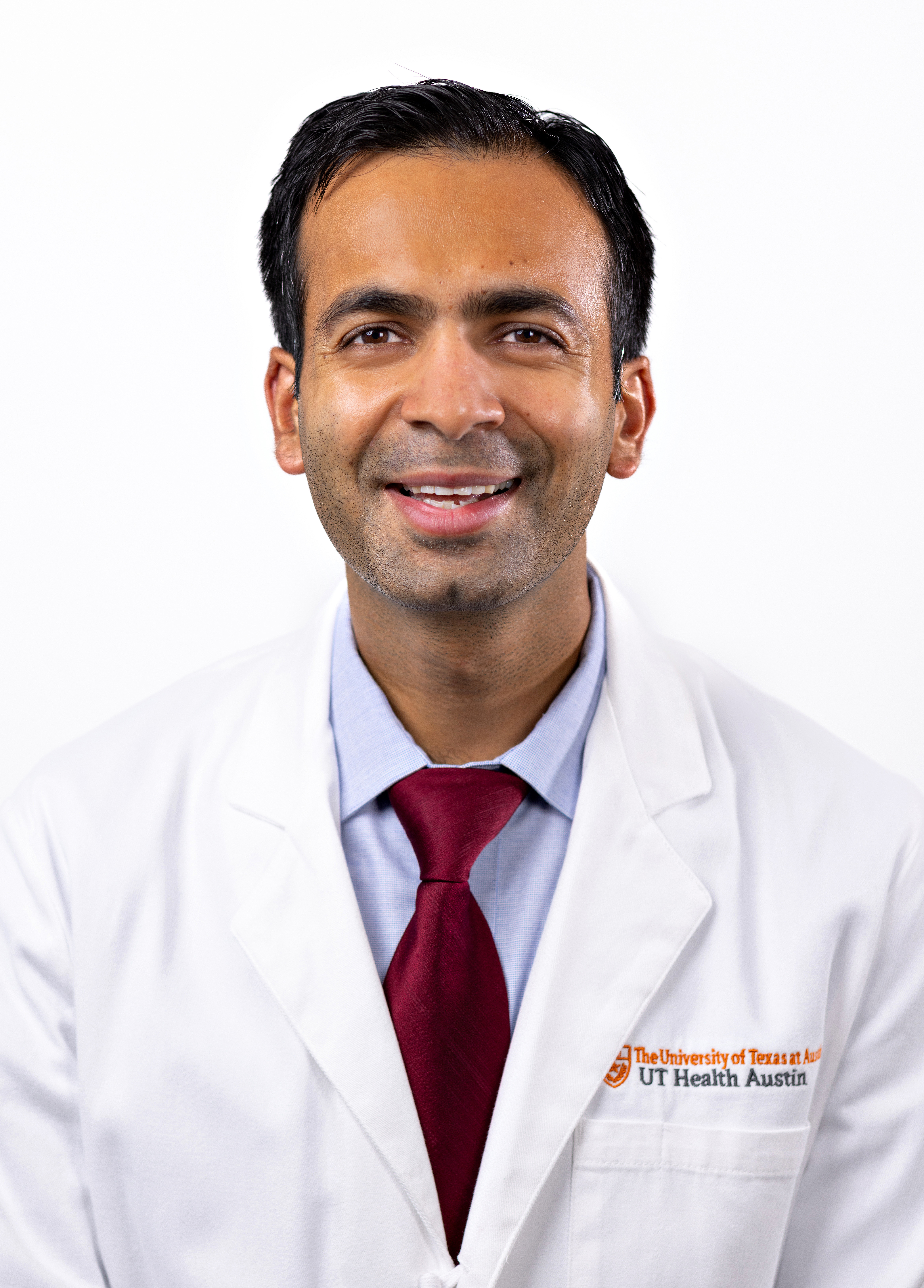 Dr. Hitesh Agrawal wearing a white coat and smiling in front of a white backdrop.