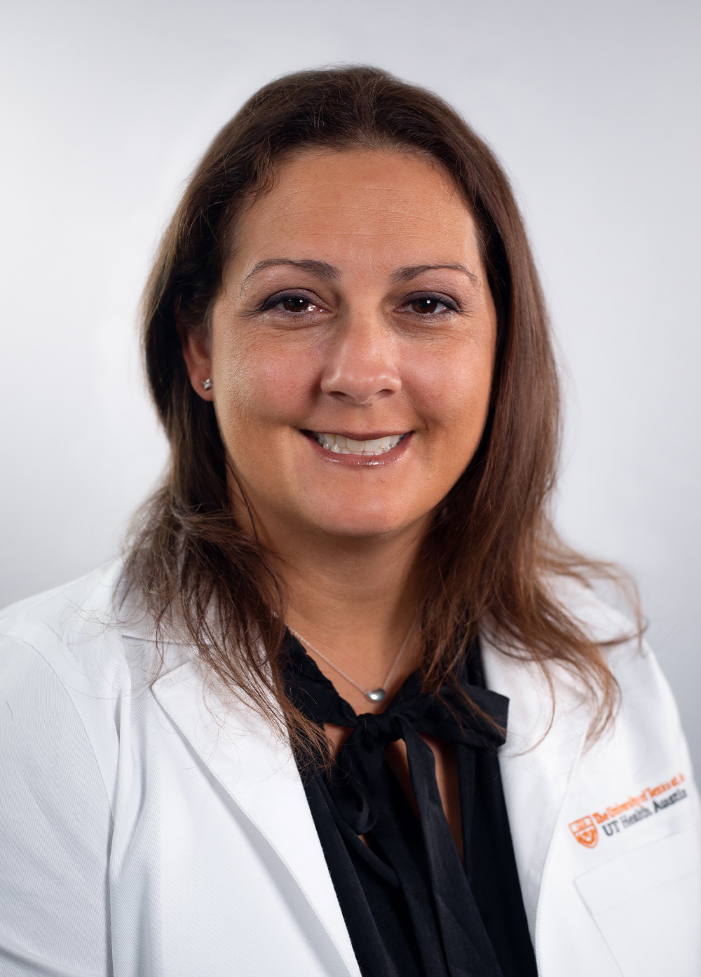 Jamie Fitzgerald wearing a white coat and smiling in front of a white backdrop.
