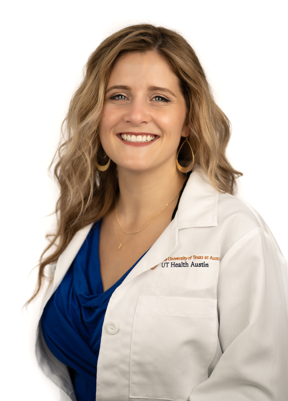 Kari LeBret-Harris wearing a white coat and smiling in front of a white backdrop.