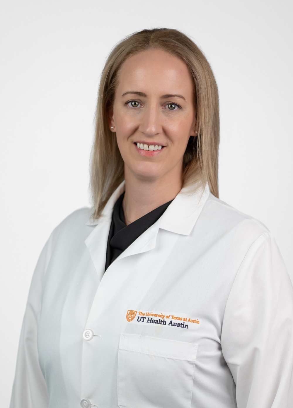 Dr. Losenno is smiling and looking at the camera. She is wearing a white coat and a black blouse.