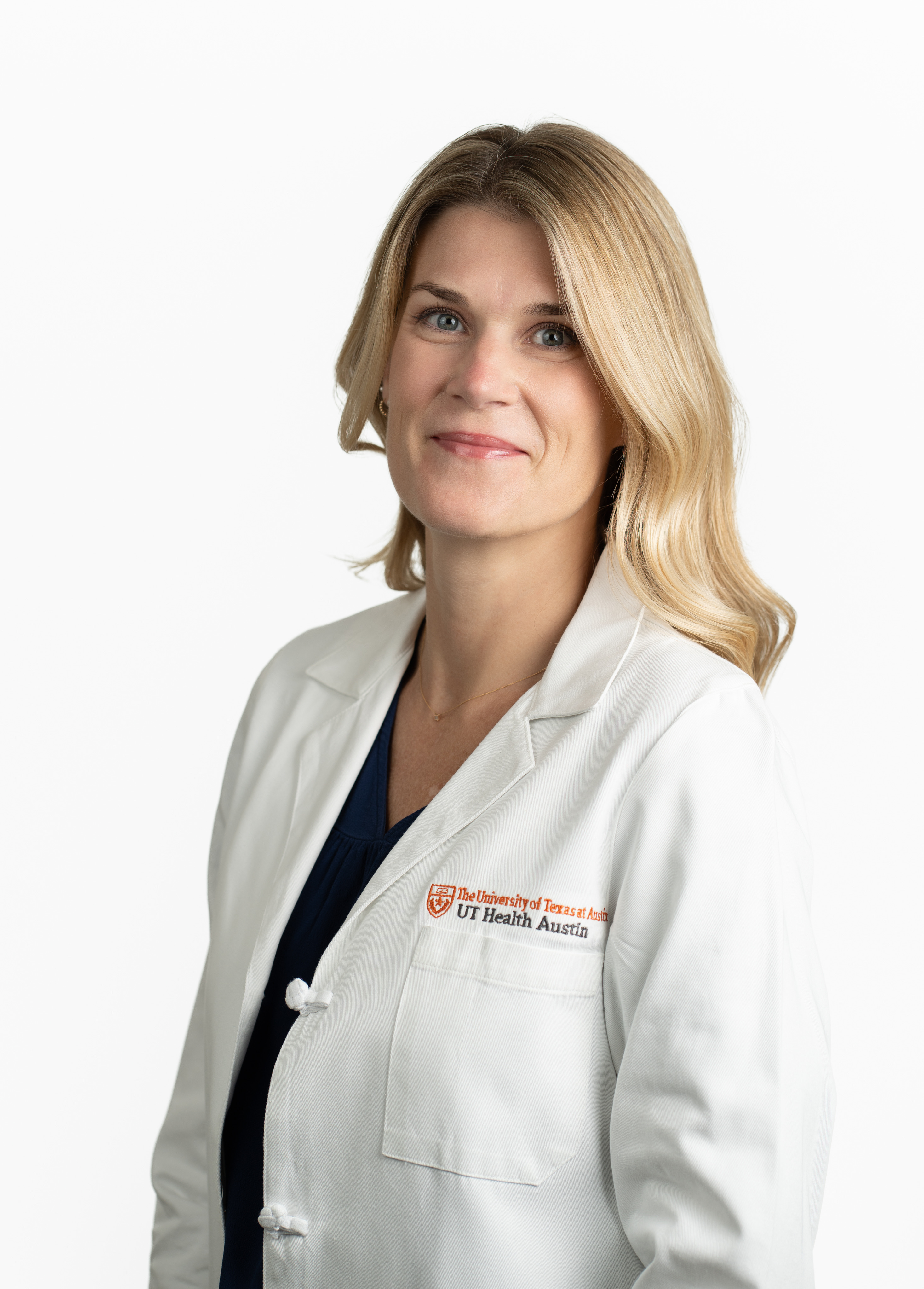 Acute care adult gerontology nurse practitioner Kelly Swap, MSN, AGACNP-BC, AGNP-C, wearing a white coat and smiling in front of a white backdrop.
