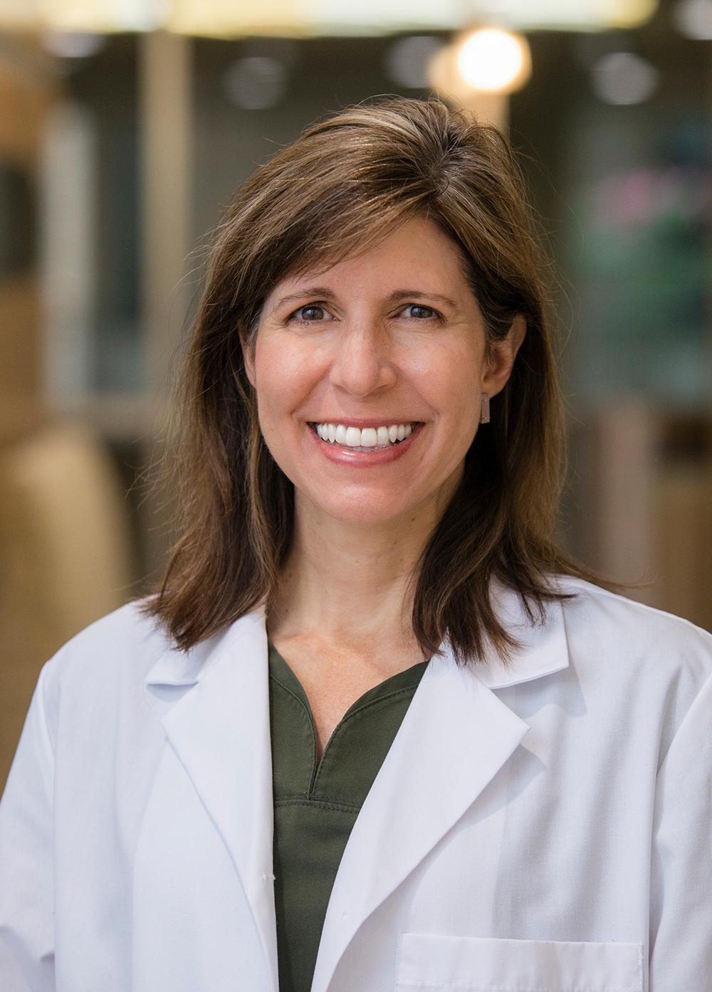 Dr. Kimberly Carter wearing a white coat and smiling indoors.