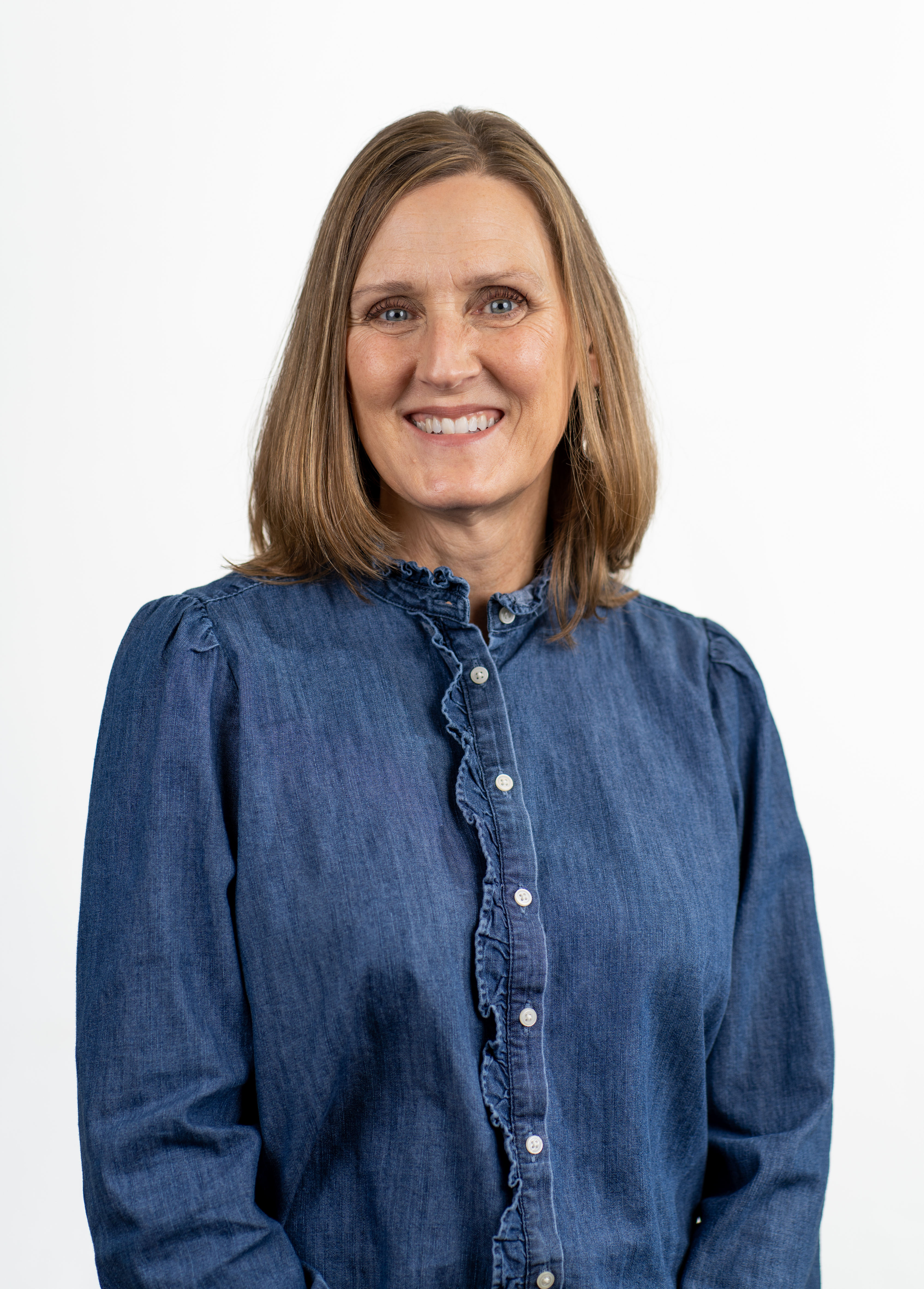 Registered dietitian Mary Beth Joy, MS, RD, LD, smiling in front of a white backdrop. She is wearing a denim blouse.