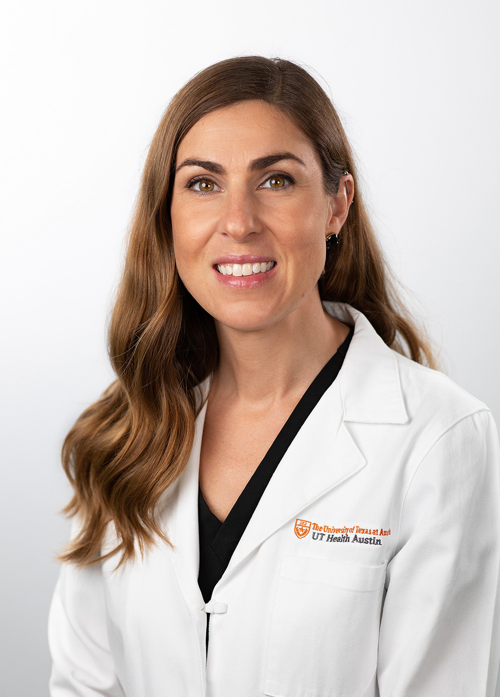 Mary Clipp wearing a white coat and smiling in front of a white backdrop.