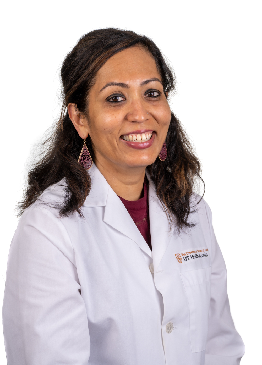 Dr. Meena Iyer wearing a white coat and smiling in front of a white backdrop.