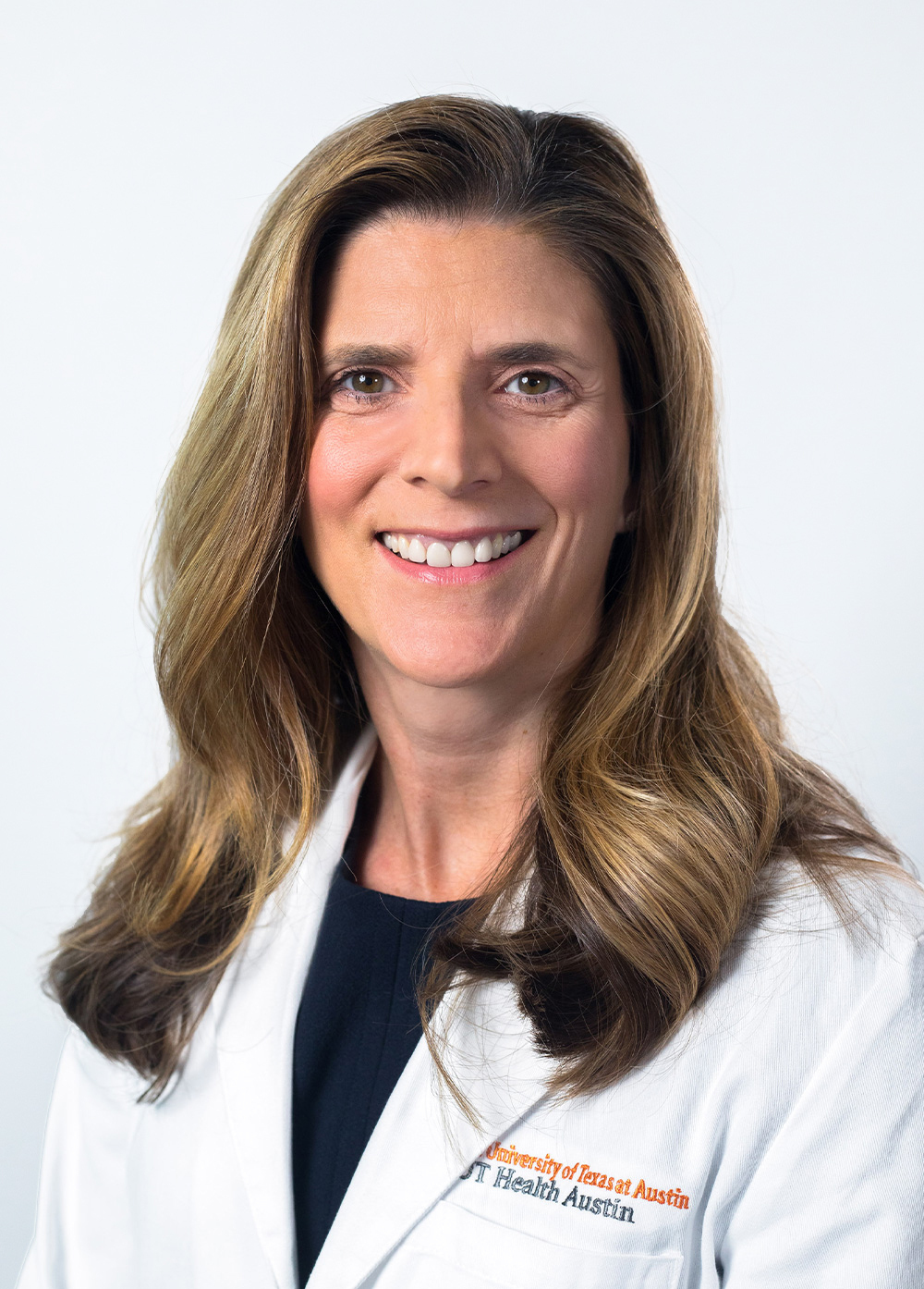 Dr. Nicole Turgeon wearing a white coat and smiling in front of a white backdrop.