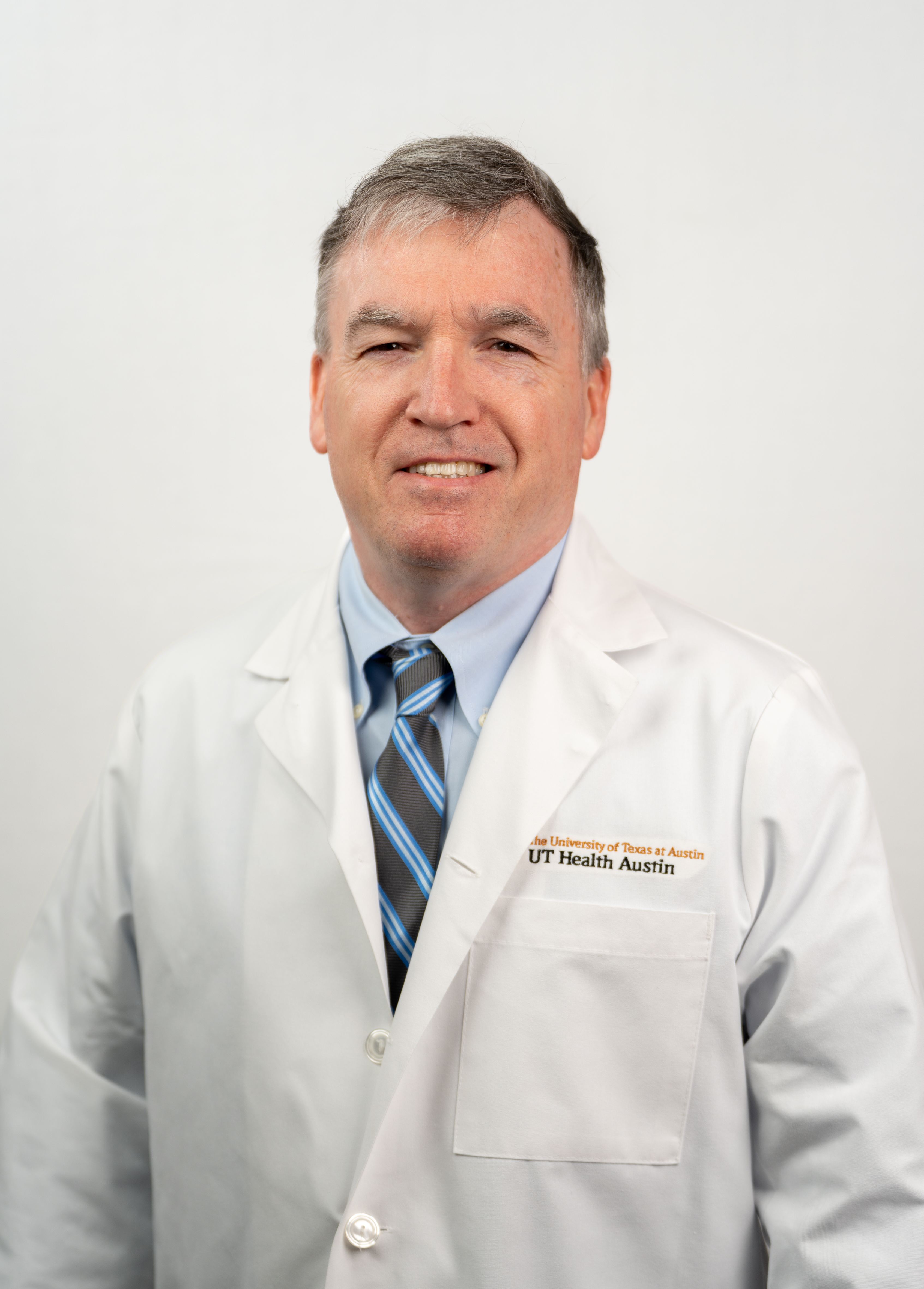 Pediatric anesthesiologist and pediatric critical care intensivist Paul Sheeran, MD, wearing a white coat and smiling in front of a white background.