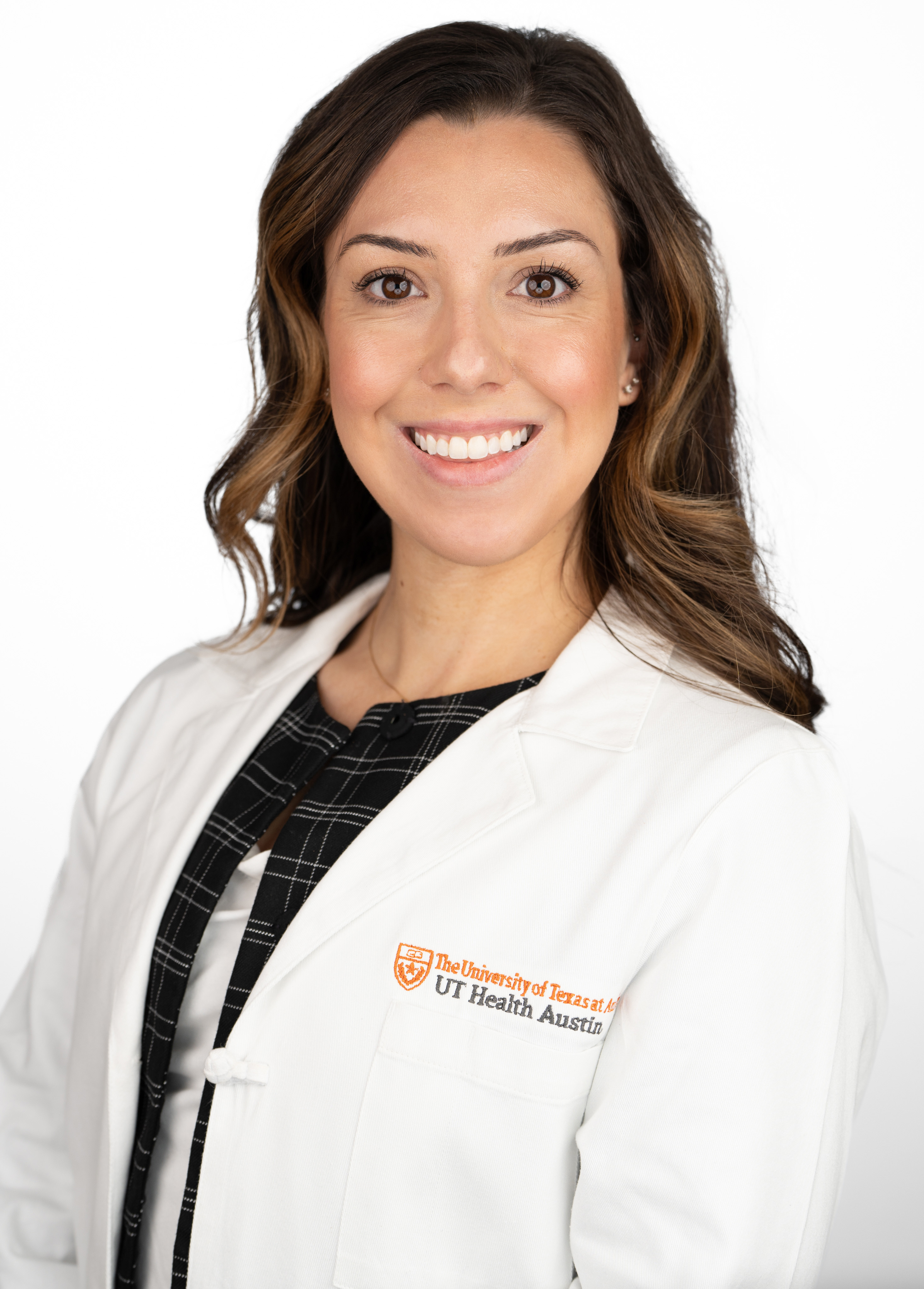Pediatric neuropsychologist Rachel Bridges, PhD, wearing a white coat and smiling in front of a white backdrop.
