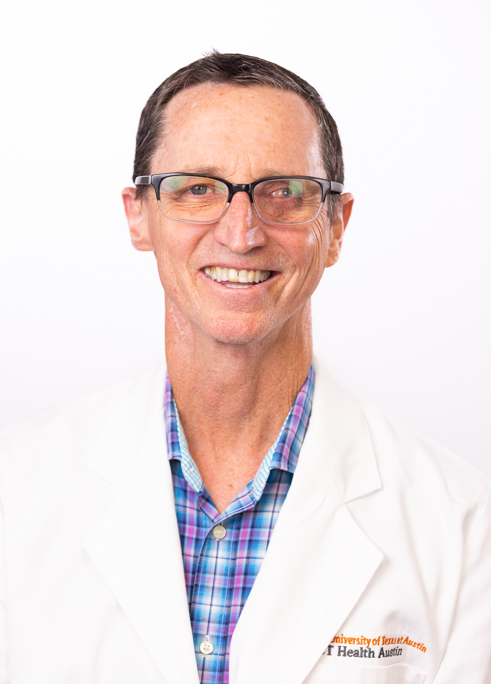 Dr. Stephen R. Deputy wearing a white coat and smiling in front of a white backdrop.