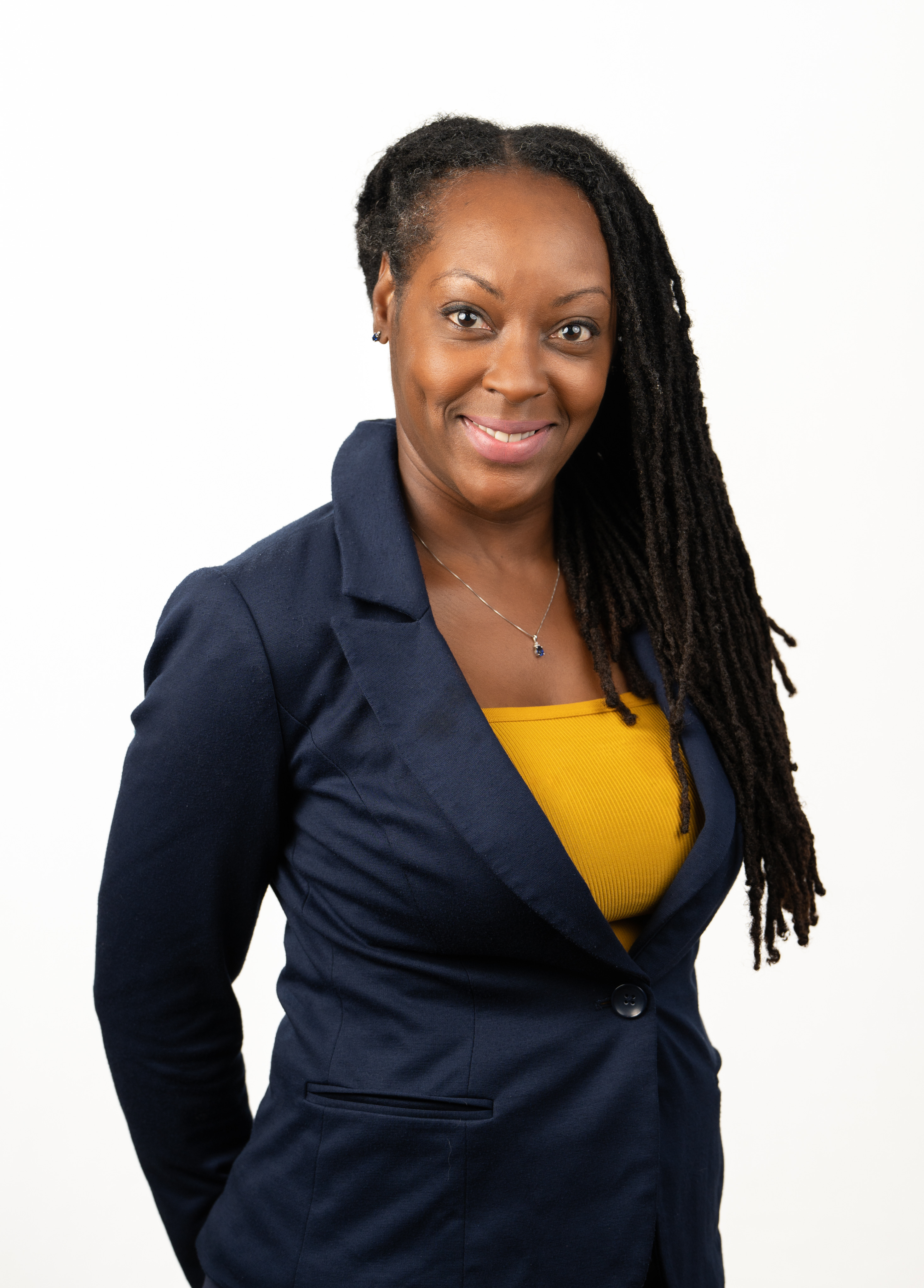 Social worker Tenisha R. Hunter, LCSW-S, wearing a navy blazer and smiling in front of a white background.