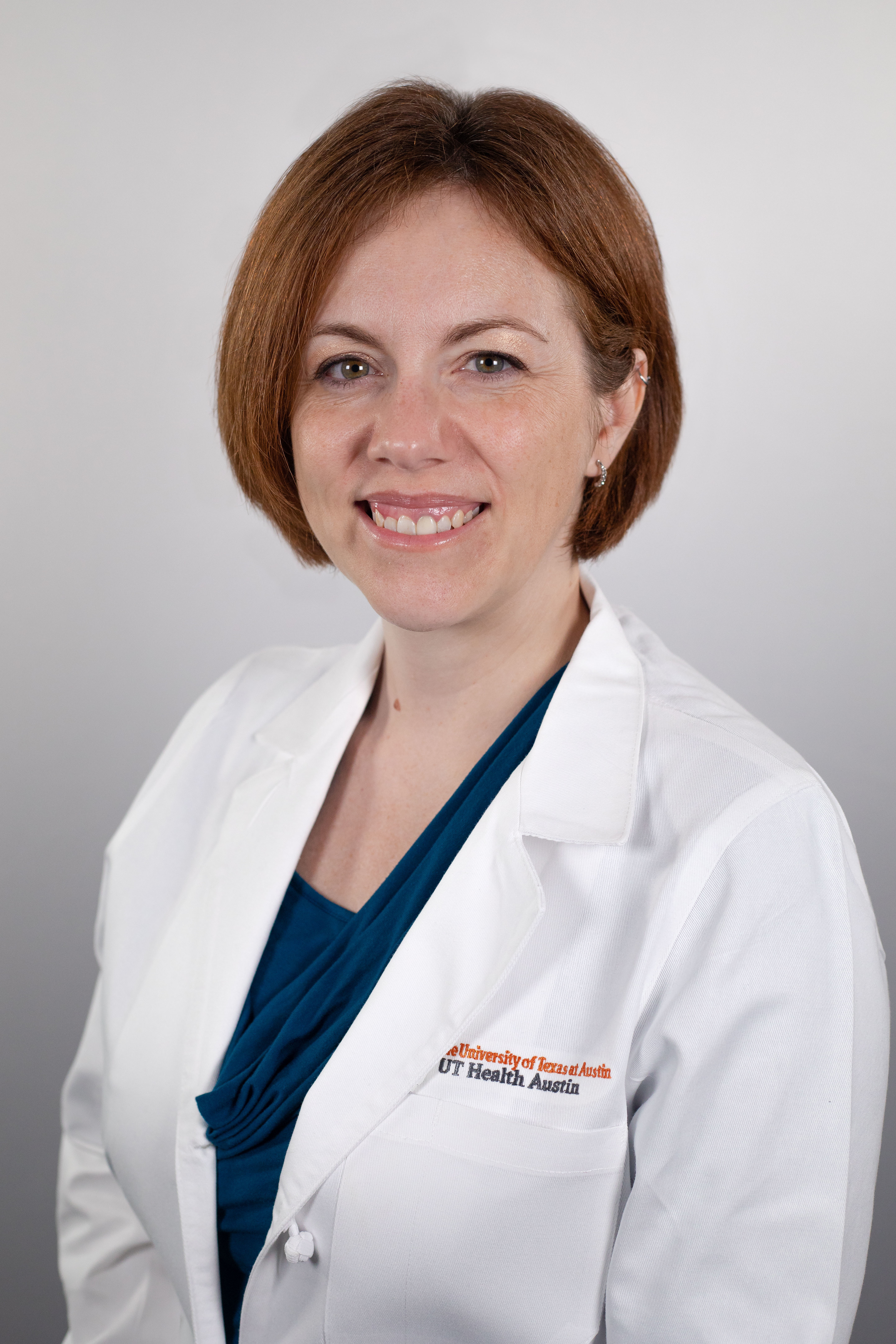 Dr. Lorie Harper wearing a white coat and smiling in front of a white backdrop.