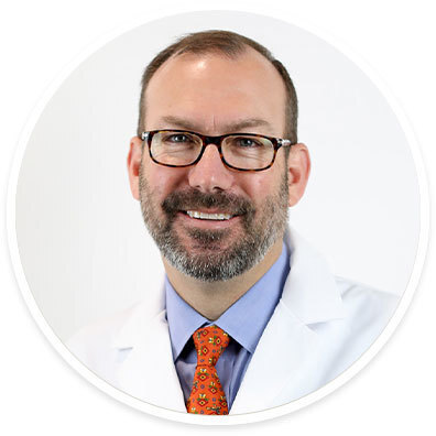Dr. F.P. "Tripp" Buckley wearing a white coat and smiling in front of a white backdrop.