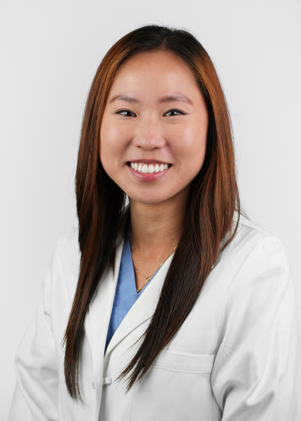 A headshot of Jane Lee. She is wearing a blue blouse and a white coat.