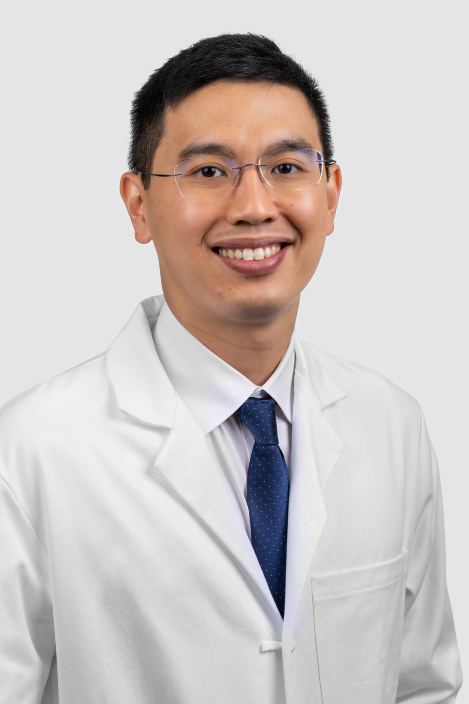 Headshot of Michael Liu. He is wearing a white shirt, blue tie, and a white coat.
